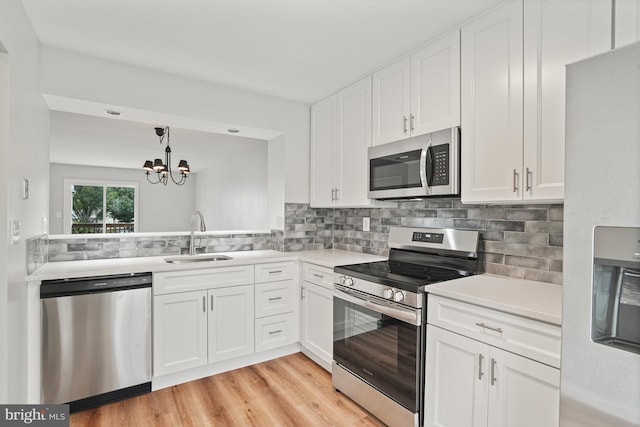 3823 9th Rd S, Arlington, VA 22204 - kitchen featuring appliances with stainless steel finishes, a sink, light countertops, a chandelier, and white cabinets