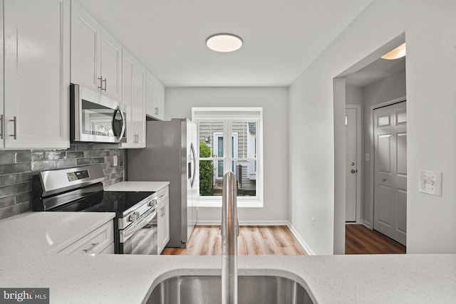 3823 9th Rd S, Arlington, VA 22204 - kitchen featuring appliances with stainless steel finishes, a sink, wood finished floors, and light stone counters