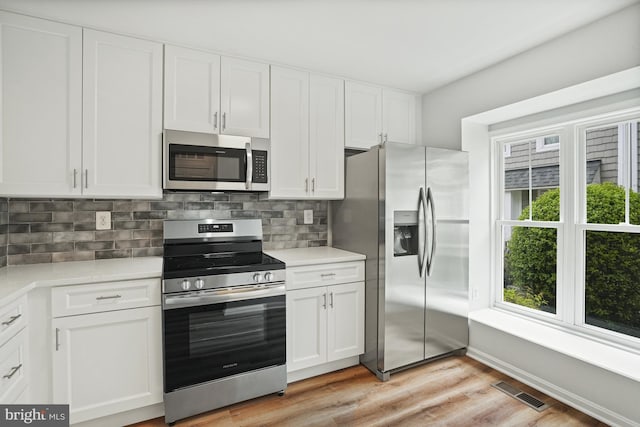 3823 9th Rd S, Arlington, VA 22204 - kitchen with stainless steel appliances, light countertops, backsplash, white cabinetry, and light wood-type flooring