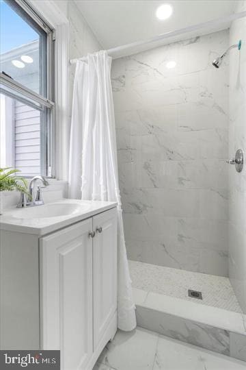 4511 Powell Ave, Baltimore, MD 21206 - full bathroom with marble look tiles, a marble finish shower, and vanity