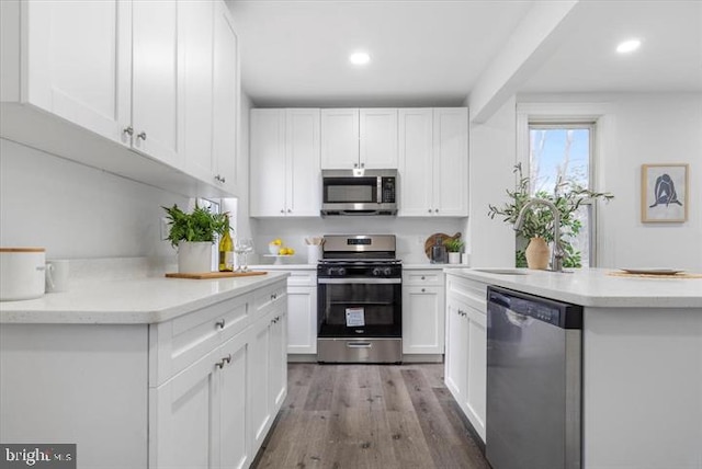 4511 Powell Ave, Baltimore, MD 21206 - kitchen featuring appliances with stainless steel finishes, a sink, white cabinets, recessed lighting, and wood finished floors