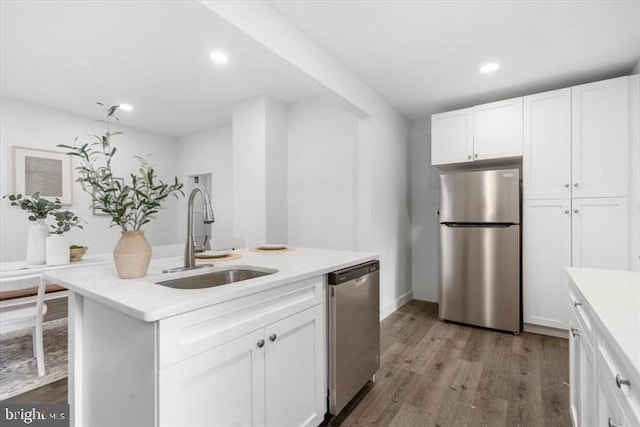4511 Powell Ave, Baltimore, MD 21206 - kitchen with appliances with stainless steel finishes, a sink, light countertops, wood finished floors, and white cabinets