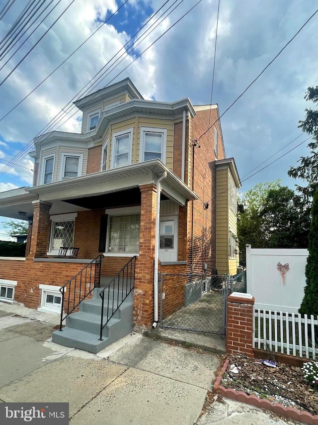 453 Bert Ave, Trenton, NJ 08629 - view of front facade featuring a porch, fence, and brick siding
