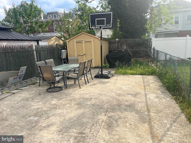 453 Bert Ave, Trenton, NJ 08629 - view of patio with outdoor dining space, a storage unit, a grill, a fenced backyard, and an outbuilding