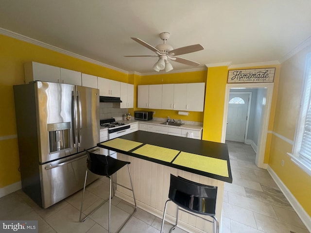 453 Bert Ave, Trenton, NJ 08629 - kitchen featuring appliances with stainless steel finishes, under cabinet range hood, crown molding, white cabinets, and a breakfast bar area