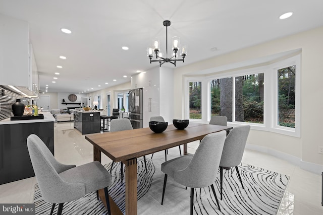 dining room with recessed lighting, healthy amount of natural light, a chandelier, and baseboards