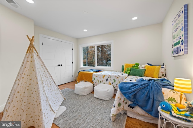 bedroom featuring wood finished floors, recessed lighting, and a closet
