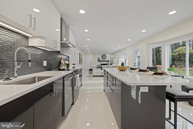 kitchen featuring a sink, modern cabinets, wall chimney exhaust hood, backsplash, and light tile patterned flooring