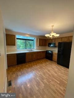 586 Wild Flower Glade, Annapolis, MD 21409 - kitchen featuring black appliances, a chandelier, light countertops, and light wood-type flooring