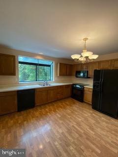 586 Wild Flower Glade, Annapolis, MD 21409 - kitchen with black appliances, a chandelier, light countertops, brown cabinets, and light wood-type flooring