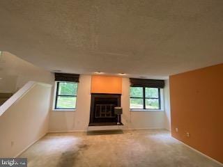586 Wild Flower Glade, Annapolis, MD 21409 - unfurnished living room featuring healthy amount of natural light, a glass covered fireplace, and baseboards