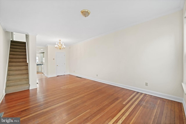 1718 N Scott St, Wilmington, DE 19806 - unfurnished living room featuring stairs, a chandelier, light wood-type flooring, baseboards, and crown molding