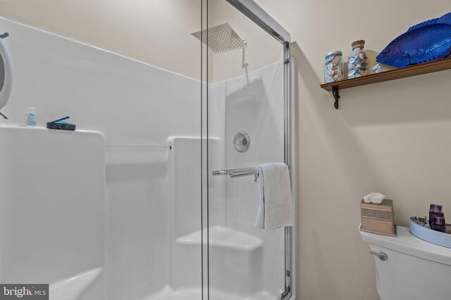 bathroom with a shower stall and toilet