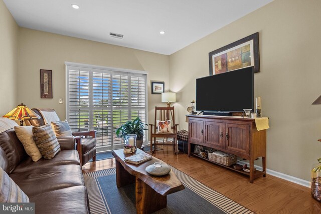 living area featuring wood finished floors, recessed lighting, and baseboards