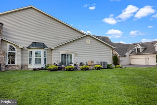 rear view of house featuring a lawn, a standing seam roof, central AC, and metal roof