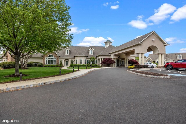 view of front facade featuring a front yard and uncovered parking