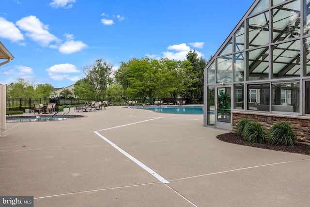 community pool featuring a patio and fence