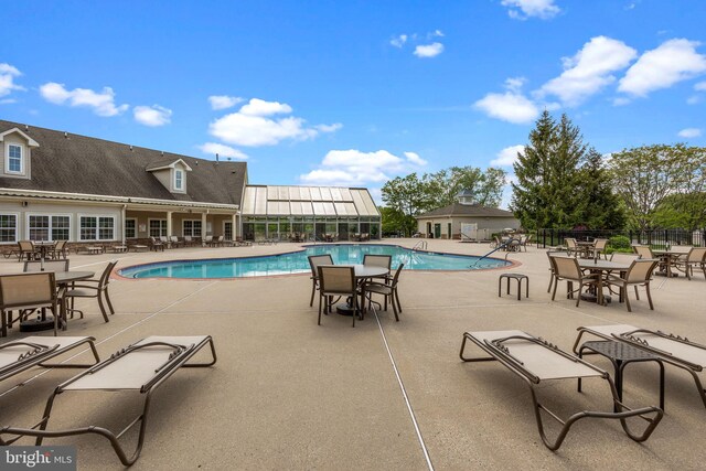 community pool with fence and a patio