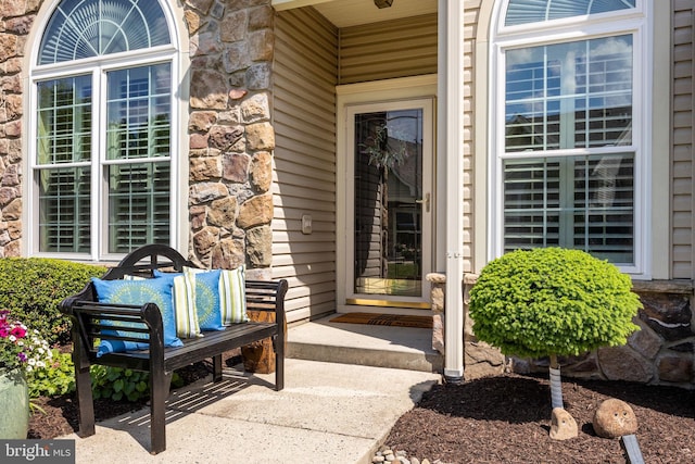 property entrance featuring stone siding and a porch