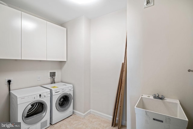 laundry room featuring cabinet space, washer and clothes dryer, and baseboards