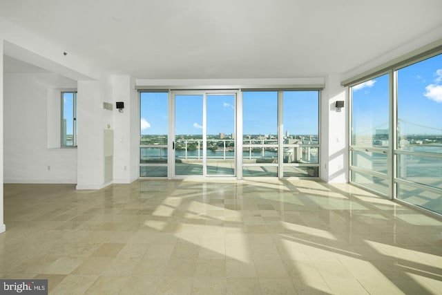 unfurnished room featuring a water view