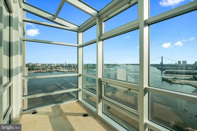 sunroom / solarium with a water view and a view of city
