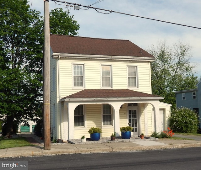 view of front facade featuring covered porch and a shingled roof