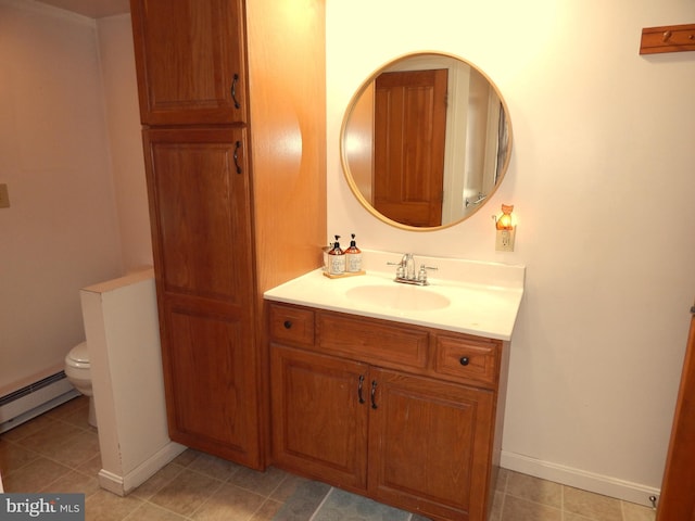 bathroom featuring toilet, vanity, baseboards, a baseboard heating unit, and tile patterned floors