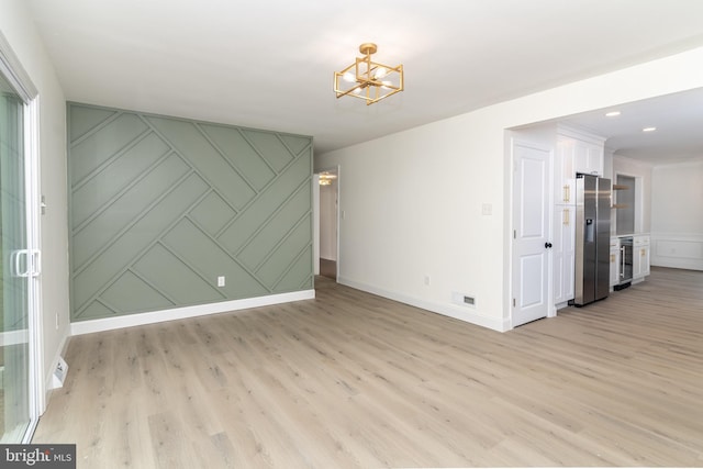 203 Shenandoah Rd, Cinnaminson, NJ 08077 - empty room featuring a decorative wall, a chandelier, light wood-type flooring, and baseboards