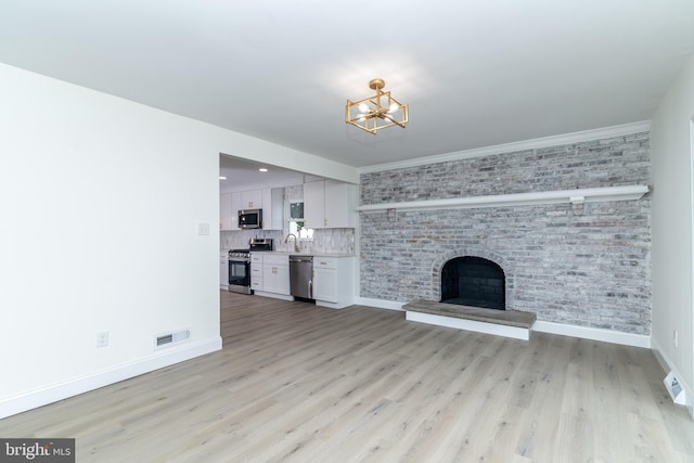 203 Shenandoah Rd, Cinnaminson, NJ 08077 - unfurnished living room with a chandelier, baseboards, light wood finished floors, and a fireplace