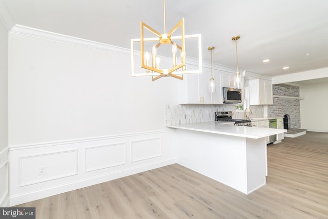 203 Shenandoah Rd, Cinnaminson, NJ 08077 - kitchen featuring stainless steel appliances, light countertops, light wood-type flooring, a chandelier, and ornamental molding