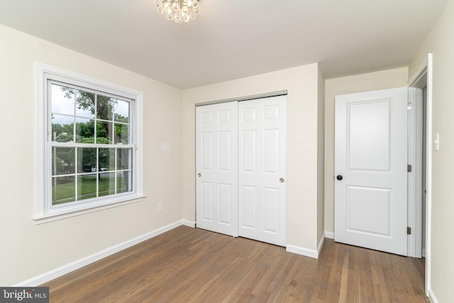 203 Shenandoah Rd, Cinnaminson, NJ 08077 - unfurnished bedroom featuring wood finished floors, baseboards, a closet, and a chandelier