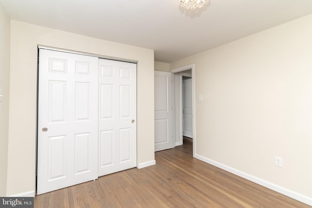 203 Shenandoah Rd, Cinnaminson, NJ 08077 - unfurnished bedroom featuring light wood-style flooring, baseboards, a closet, and a chandelier