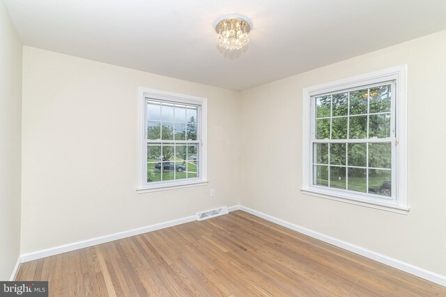 203 Shenandoah Rd, Cinnaminson, NJ 08077 - empty room featuring baseboards, wood finished floors, and a chandelier