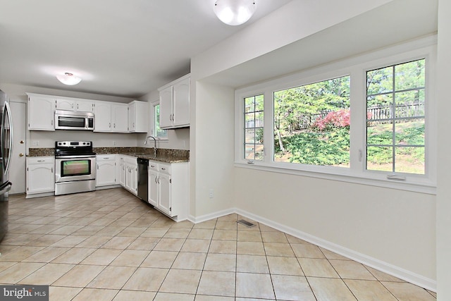 4785 Catterick Ct, Fairfax, VA 22032 - kitchen featuring appliances with stainless steel finishes, a sink, light tile patterned flooring, white cabinets, and dark stone counters