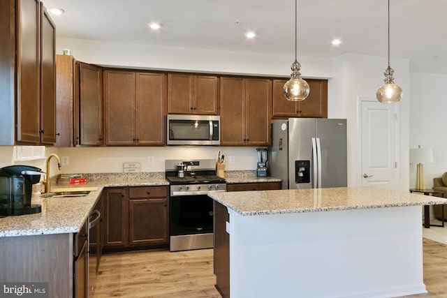 340 Shipyard Dr, Cambridge, MD 21613 - kitchen featuring appliances with stainless steel finishes, a sink, light wood finished floors, light stone counters, and recessed lighting