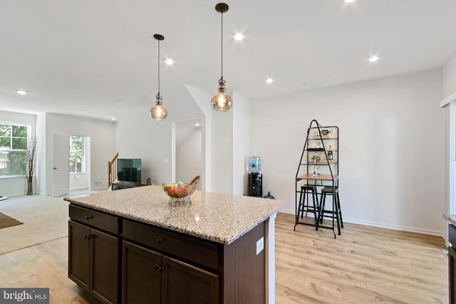 340 Shipyard Dr, Cambridge, MD 21613 - kitchen featuring light wood finished floors, dark brown cabinets, a kitchen island, pendant lighting, and open floor plan