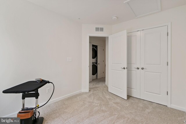340 Shipyard Dr, Cambridge, MD 21613 - unfurnished bedroom with stacked washing machine and dryer, light carpet, baseboards, and a closet