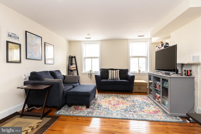 living area featuring hardwood / wood-style flooring and baseboards