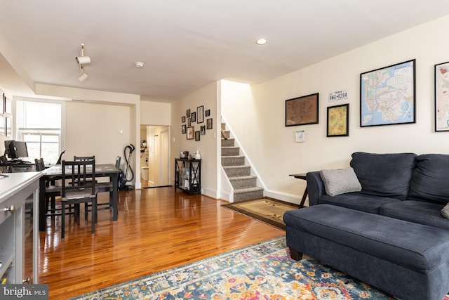 living area with wood finished floors, stairs, baseboards, and recessed lighting