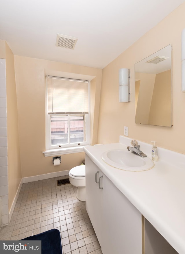 bathroom featuring toilet, vanity, baseboards, and tile patterned floors