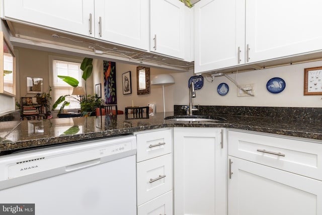 kitchen featuring dishwasher, a sink, white cabinets, and dark stone countertops