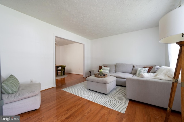 4783 Jaybird Ct, Waldorf, MD 20603 - living room with wood finished floors, a textured ceiling, and baseboards