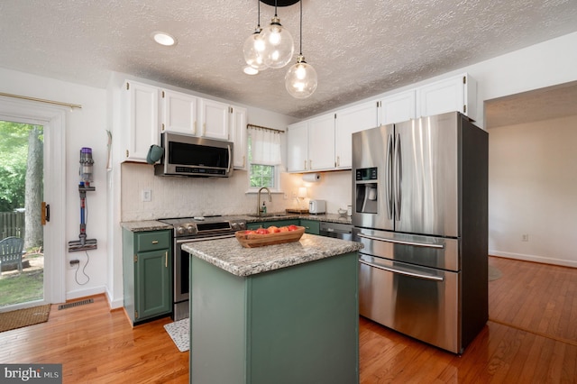 4783 Jaybird Ct, Waldorf, MD 20603 - kitchen with stainless steel appliances, green cabinetry, white cabinetry, light wood-type flooring, and decorative backsplash