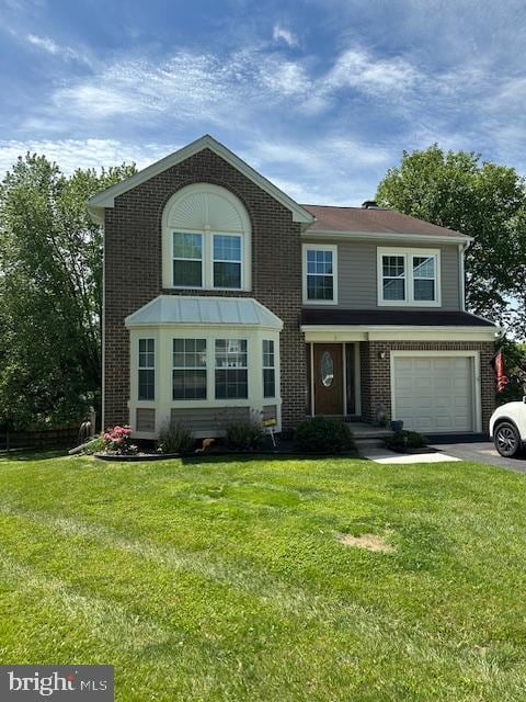 view of front of home featuring brick siding, asphalt driveway, an attached garage, and a front yard