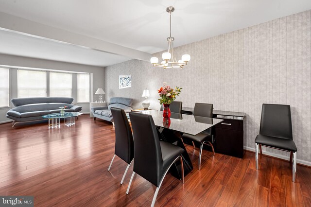 dining area with wallpapered walls, a chandelier, dark wood finished floors, and baseboards