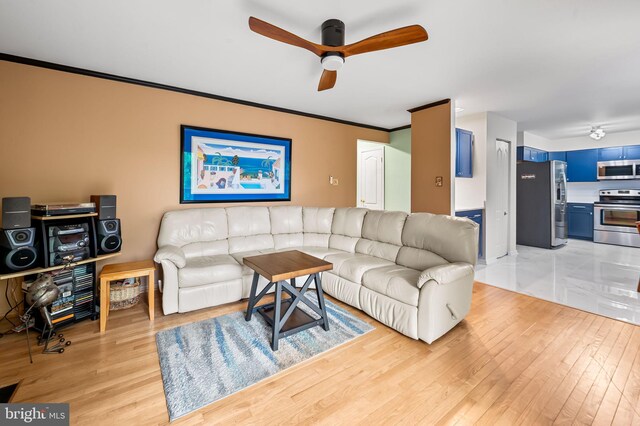 living area with light wood finished floors, ceiling fan, and ornamental molding