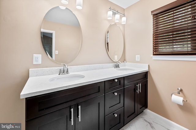 full bathroom with marble finish flooring, baseboards, and double vanity