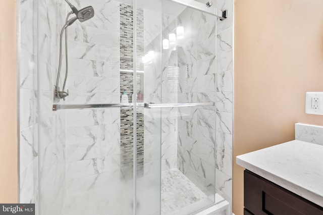 bathroom with a marble finish shower and vanity