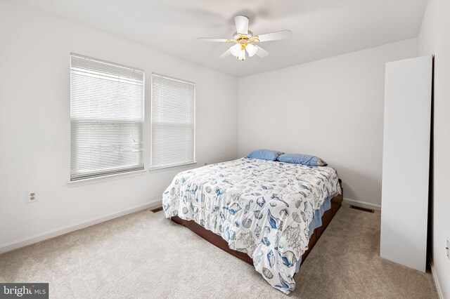 carpeted bedroom featuring baseboards and ceiling fan